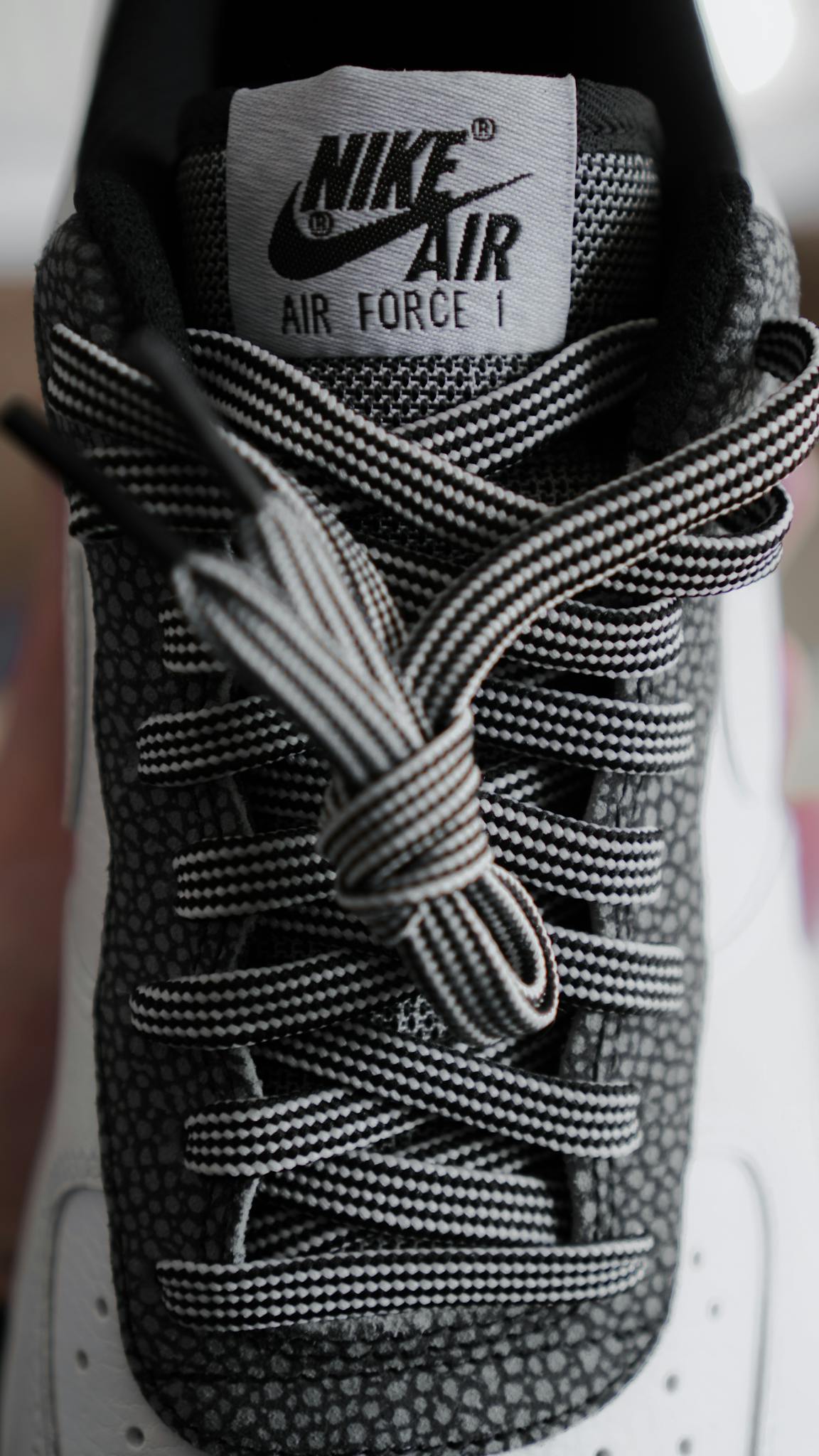 Detailed close-up shot of a modern black and white sneaker with unique textured design.